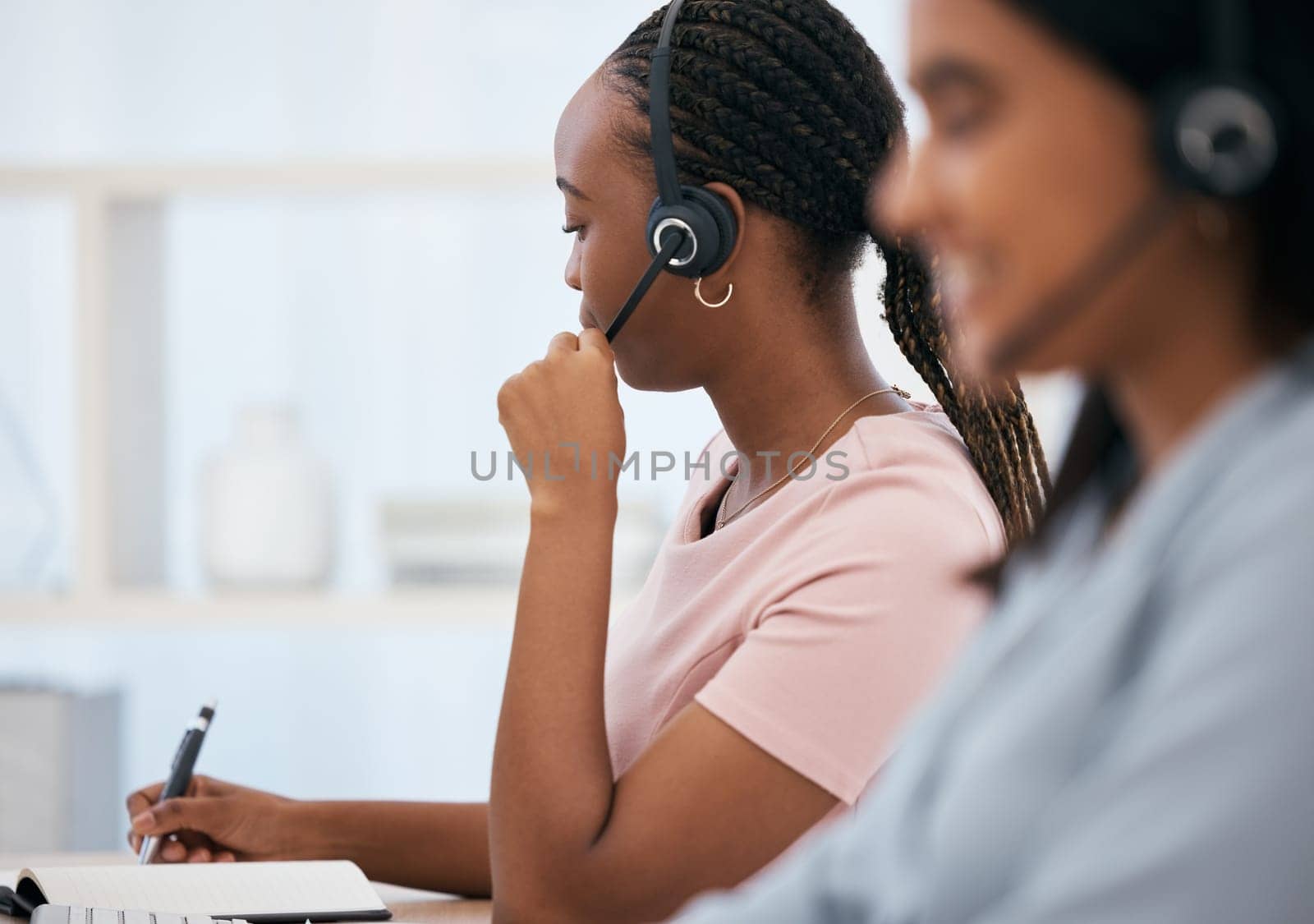 Black woman, notebook writing or headset in call center, contact us or crm consulting office in telemarketing help. Receptionist, consultant agent or customer support workers in communication company.