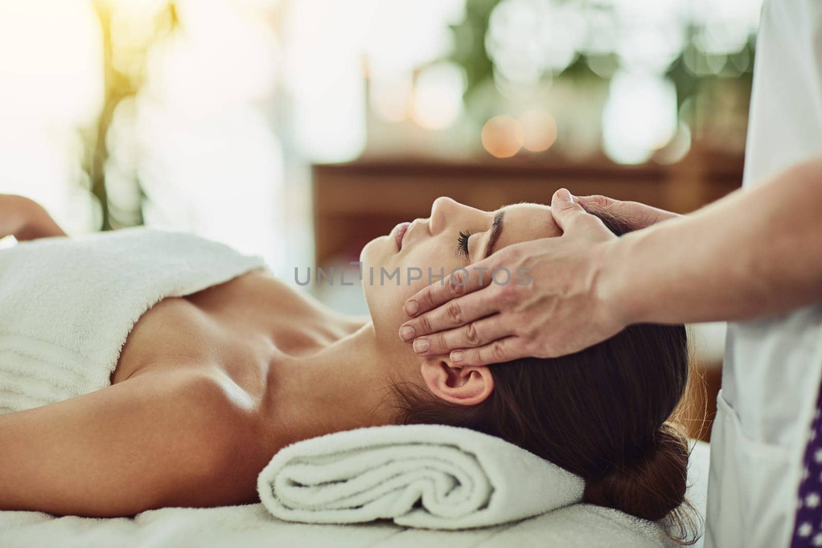 Spend a little time on yourself. an attractive young woman getting massaged at a beauty spa. by YuriArcurs