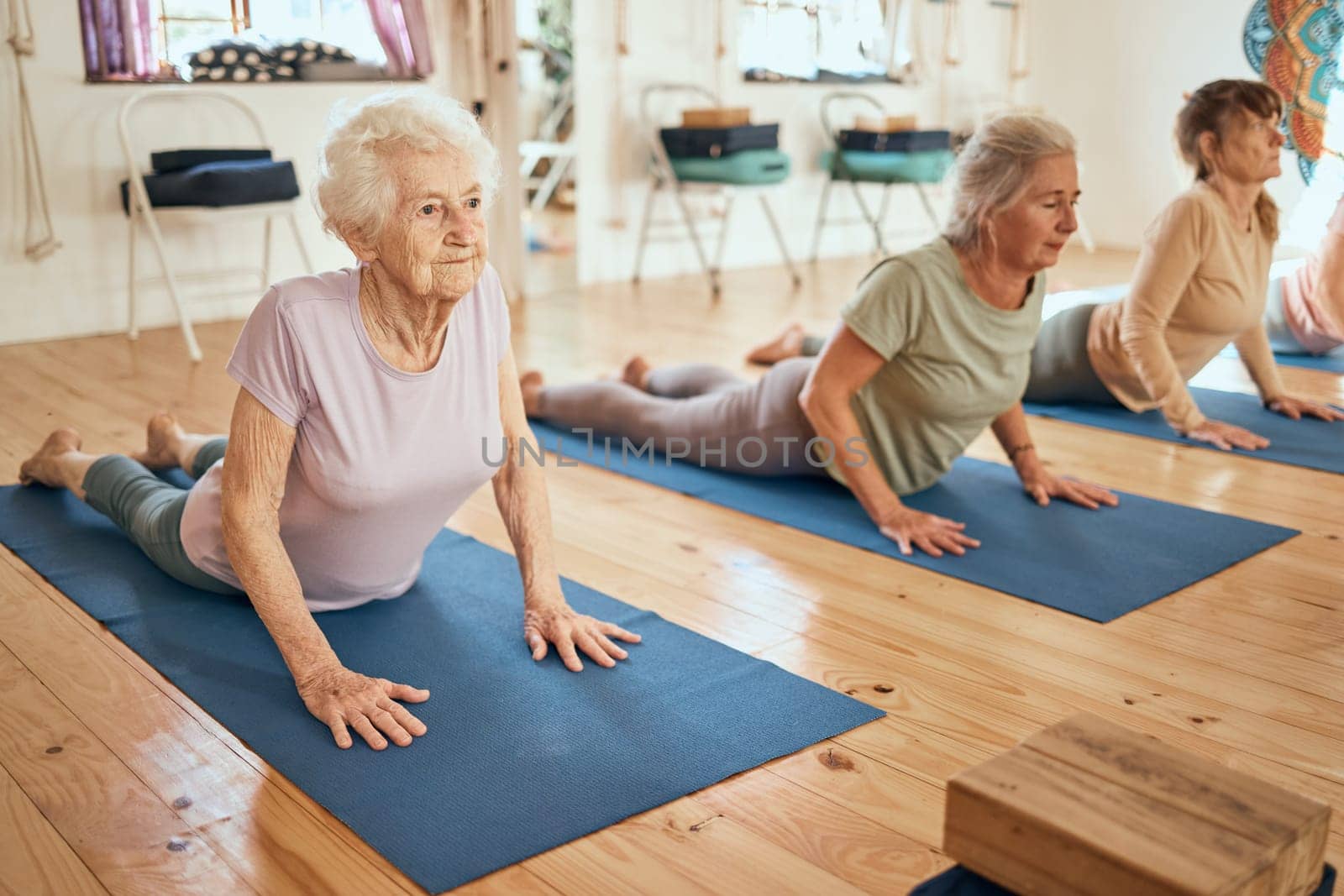 Yoga, stretching and senior women at a wellness, rehabilitation and retirement spa community for exercise, fitness and health. Workout, pilates and healthy elderly people, friends or group on floor.