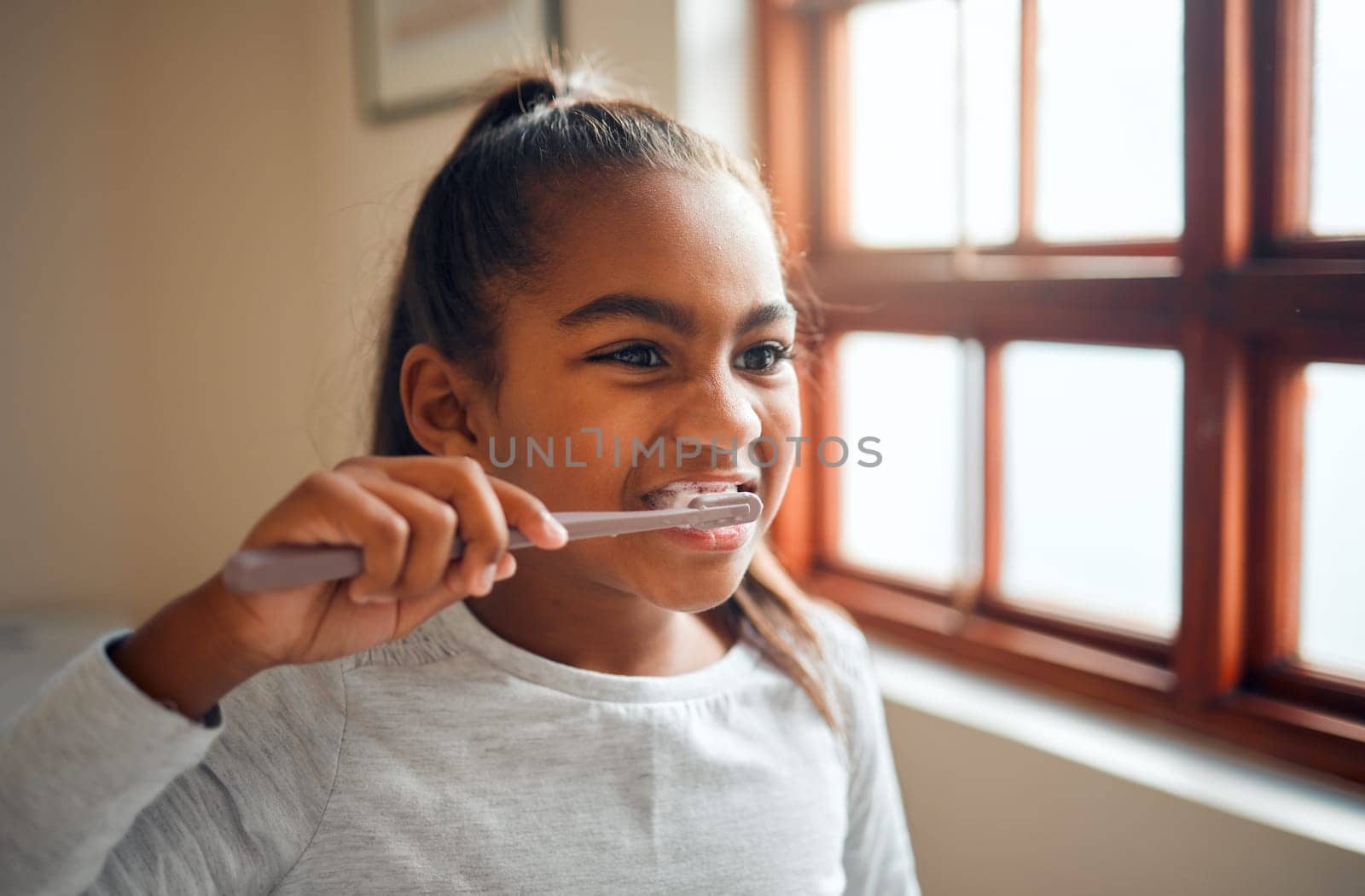 Girl brushing teeth, toothbrush for hygiene and clean mouth, fresh breath for oral care and dental health. Black child cleaning with toothpaste in bathroom, wellness at family home and healthy gums by YuriArcurs