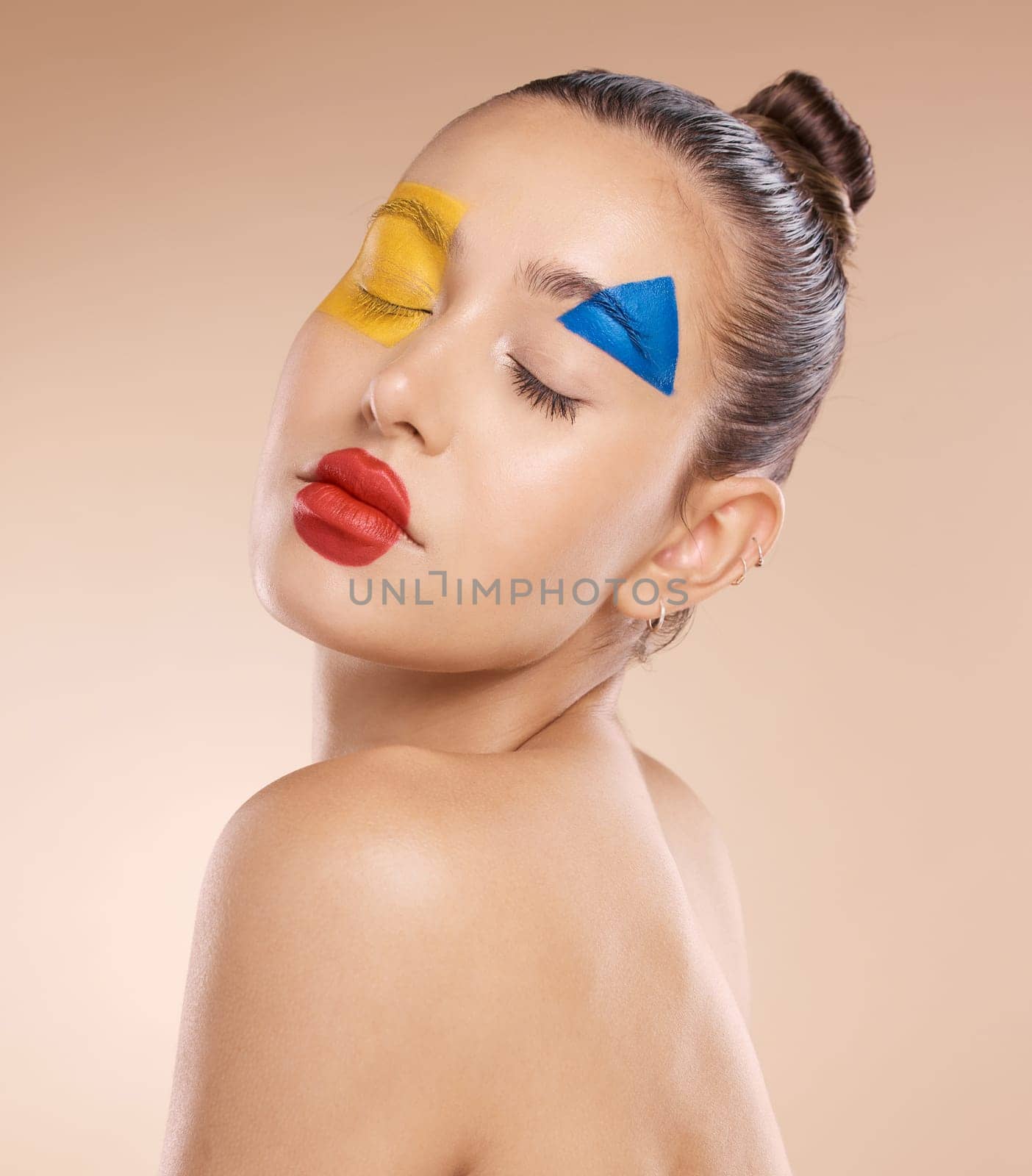 Woman, creative clown makeup on face and close eyes expression. Portrait of beauty cosmetic skincare model, circus or fantasy abstract facial paint and art design against orange studio background.
