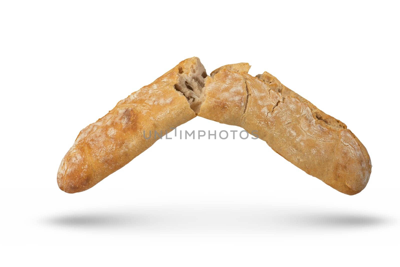 A loaf of Italian fresh ciabatta bread is broken into 2 parts on a white isolated background. Bread hanging or falling on a white background. Italian bread, side view. by SERSOL