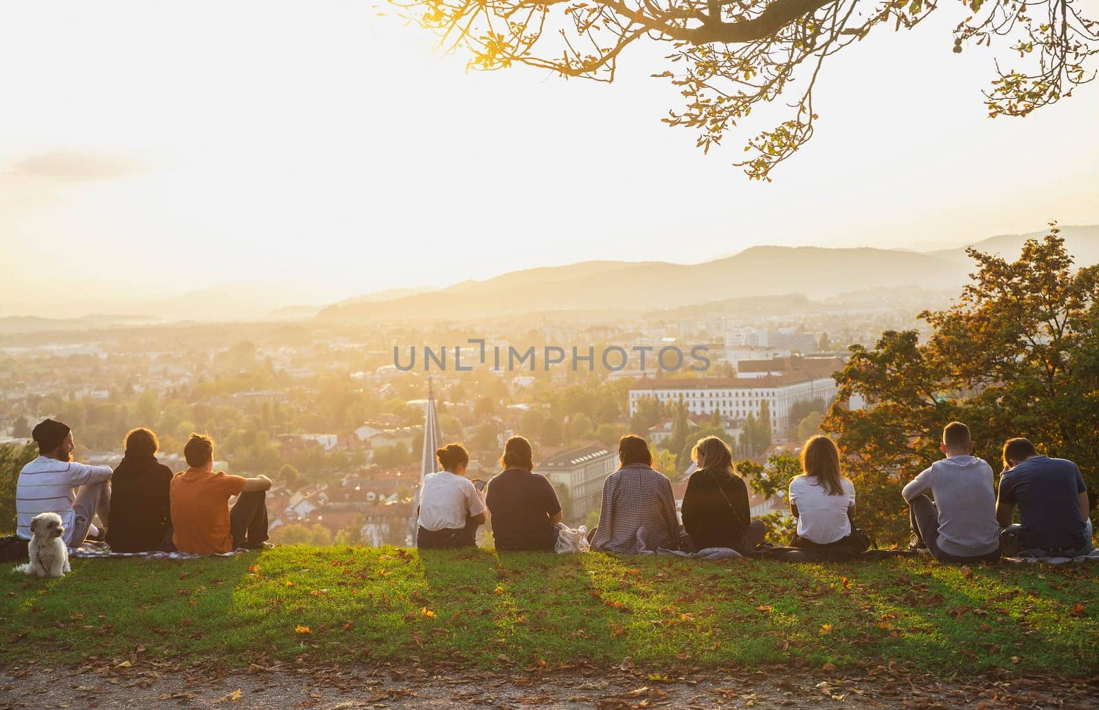 Ljubljana, Slovenia, October 2020: People sit on the mountain and admire the sunset over the autumn Ljubljana