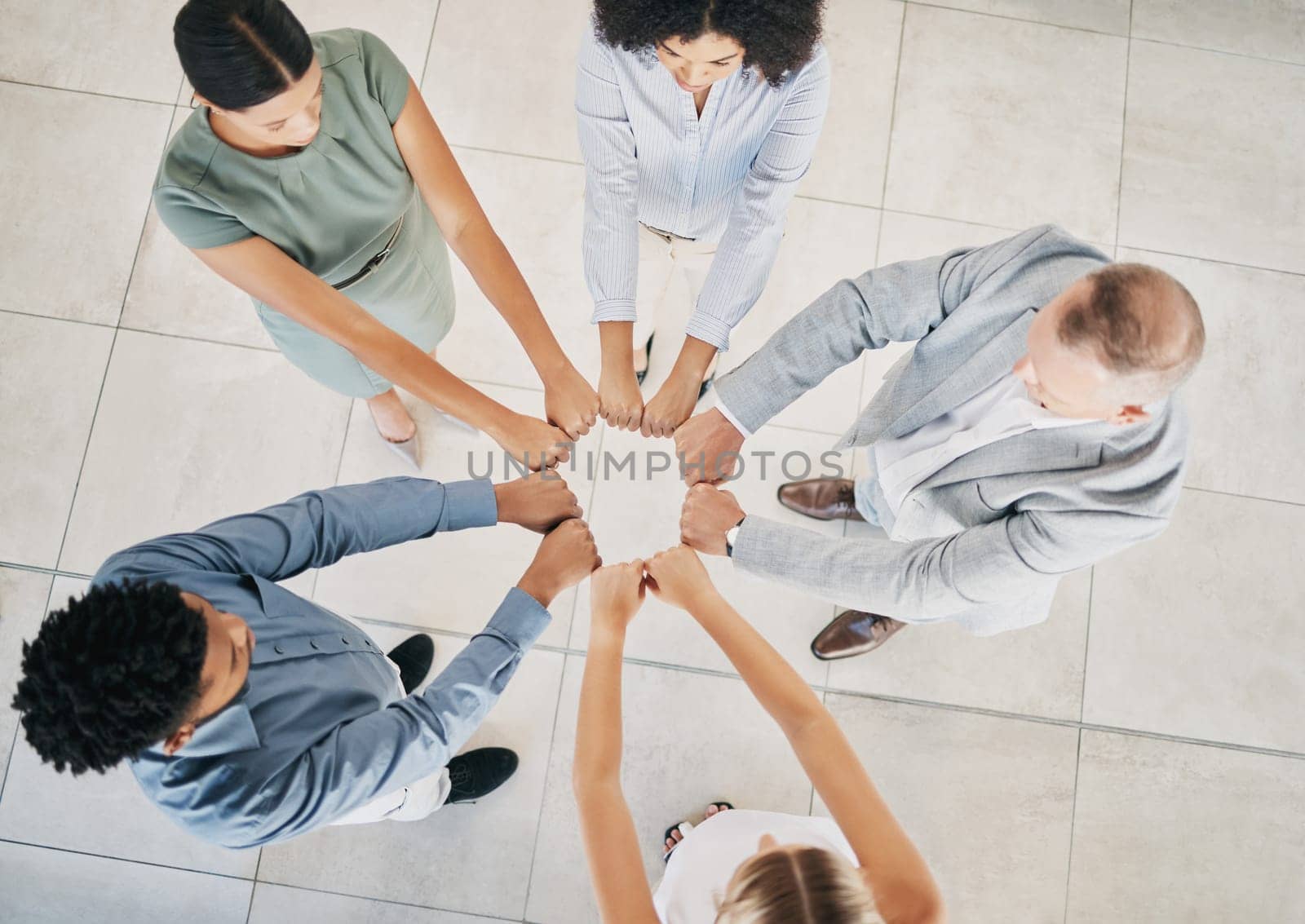 Above, business people and fist bump circle in office for teamwork, motivation and support for success. Corporate group, vision and team building in workplace with diversity, solidarity and mission by YuriArcurs