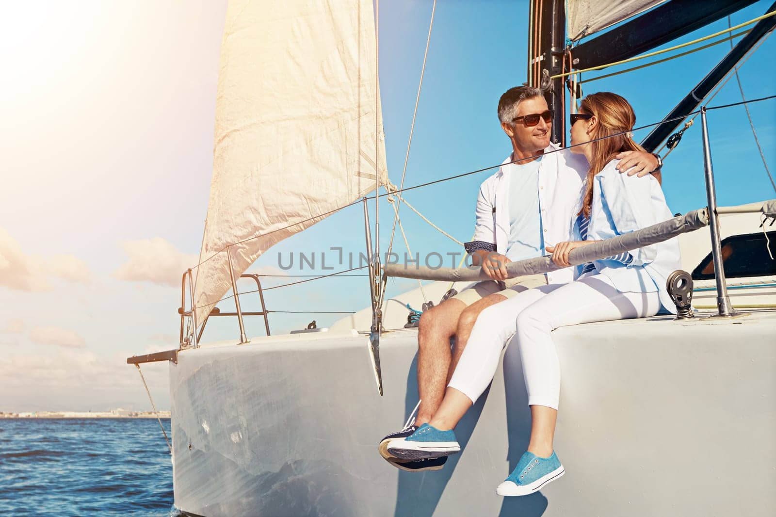 Summer, yacht and love with a couple dating on the ocean for travel, romance or honeymoon celebration. Water, luxury or cruise with a married man and woman sitting together on a boat out at sea.