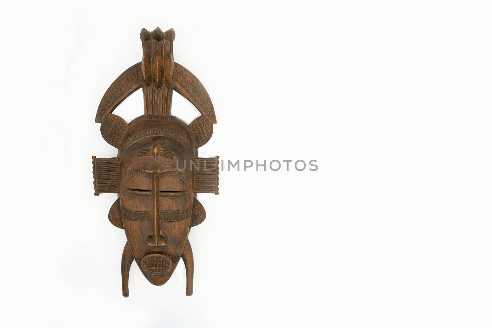Brown wooden mask isolated on a white background Copy space