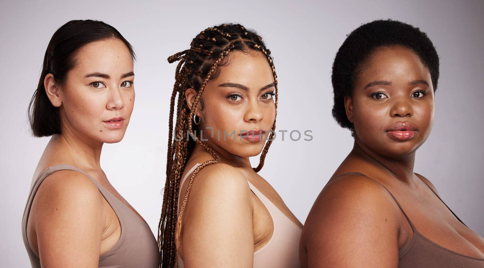Women, diversity and studio portrait with support for trust, underwear or skincare for beauty aesthetic. Model, asian and black woman with inclusion, makeup or wellness with skin health by background.