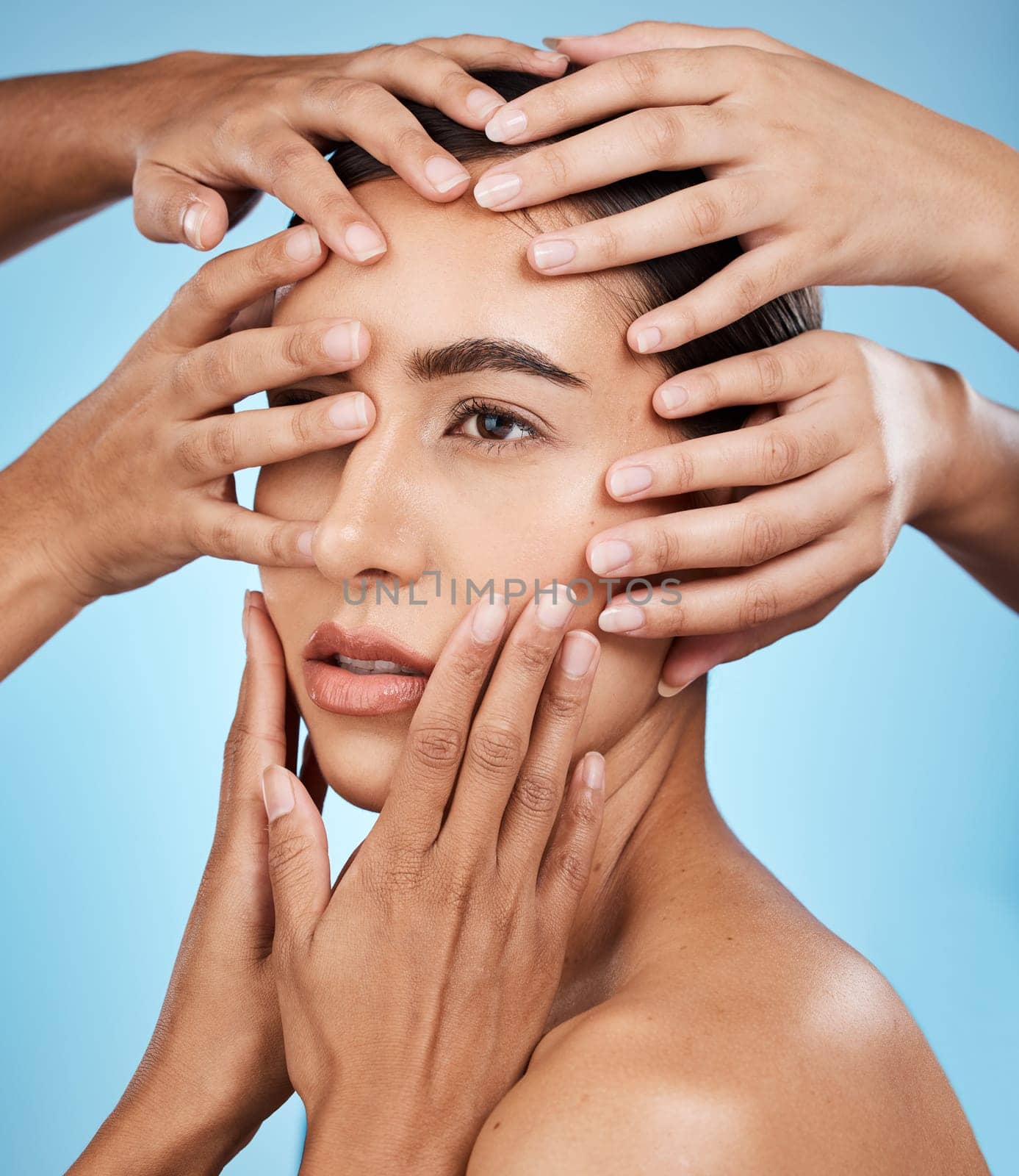 Touching, hands and face of a woman for skincare isolated on a blue background in a studio. Consultation, check and girl with people feeling for facial acne, problem and dermatology on a backdrop.