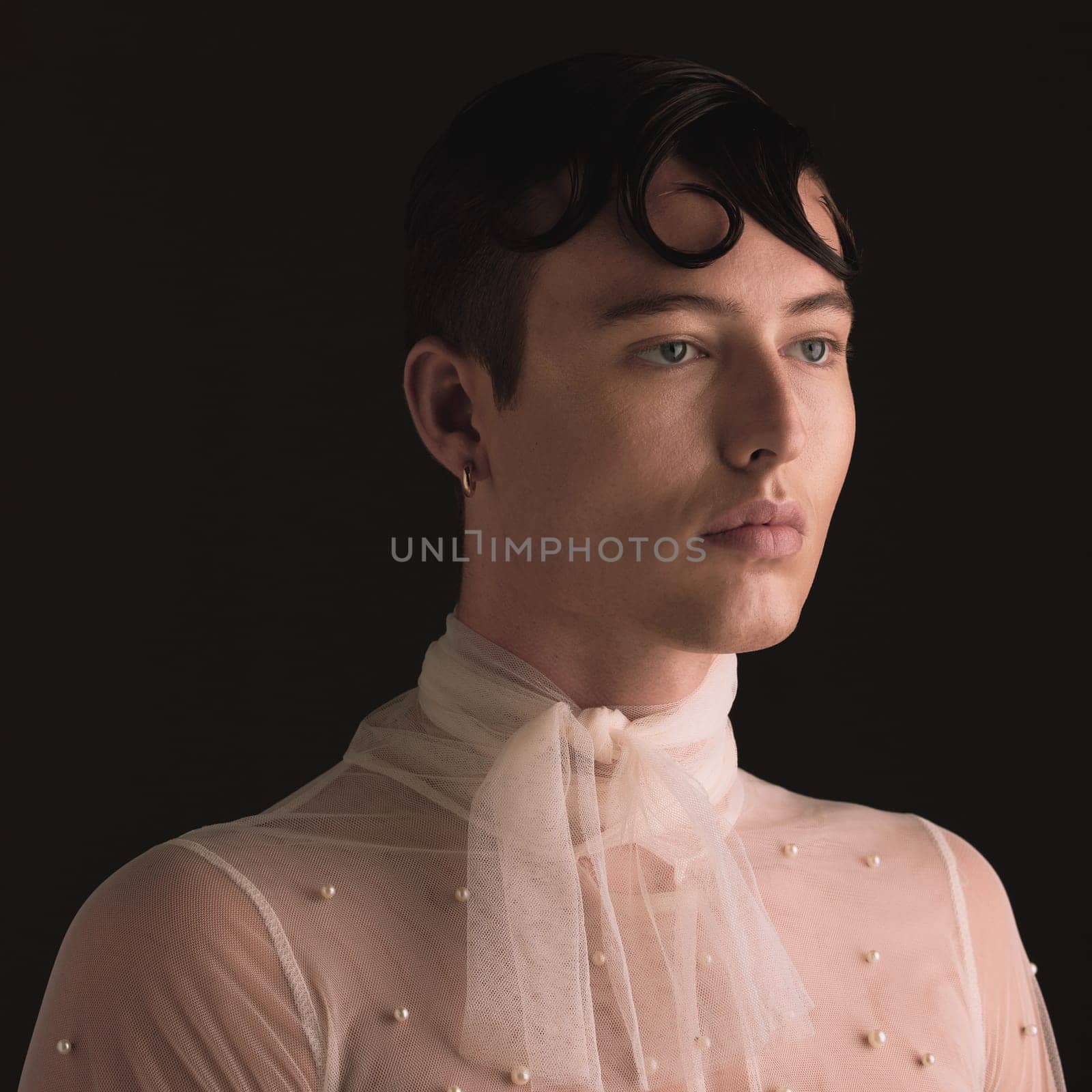 Gender neutral, fashion face and vintage aesthetic with designer clothing and faux pearls in studio. Isolated, black background and lgbtq or gay gen z with jewelry and creativity and non binary art by YuriArcurs