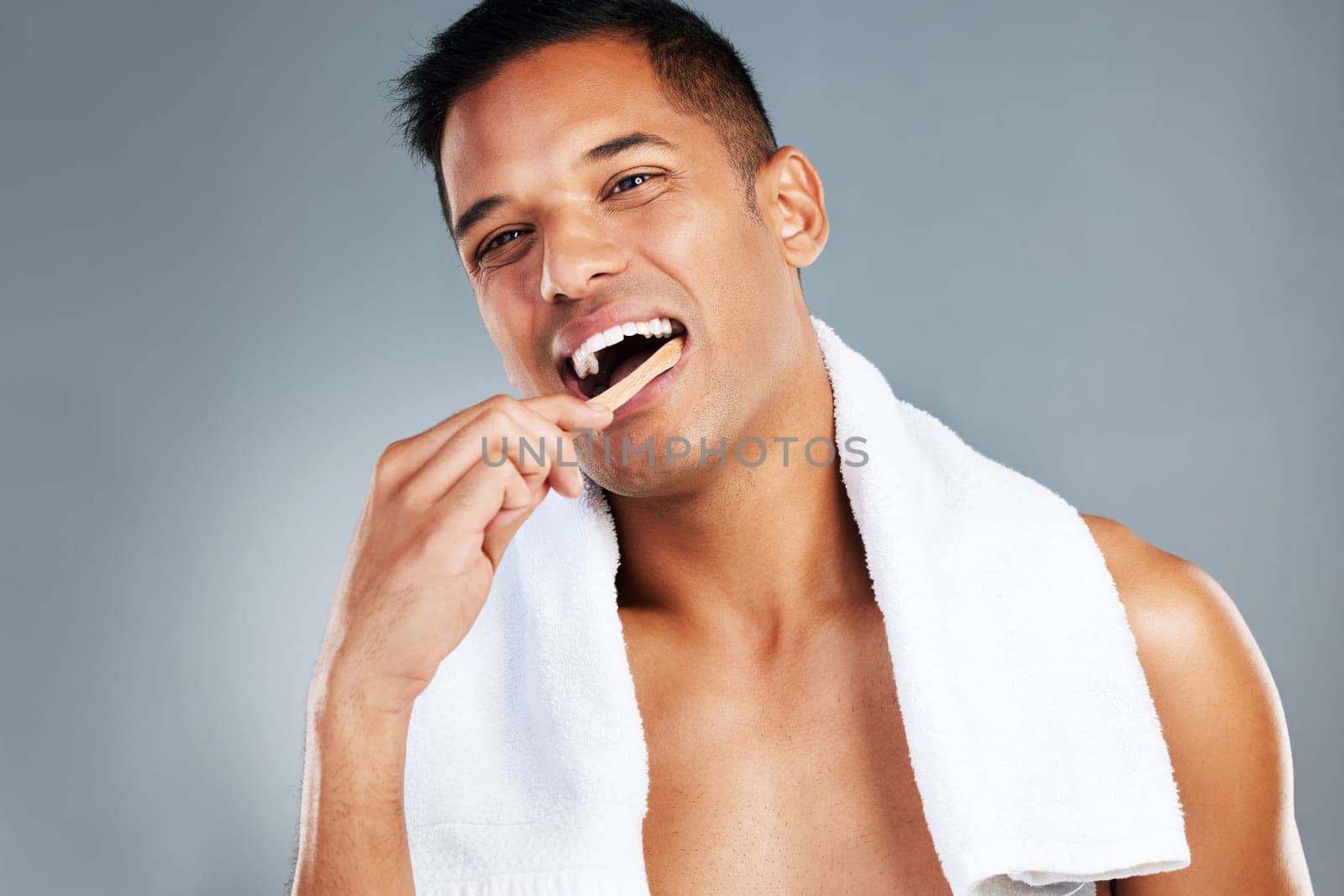 Man, toothbrush and teeth for dental hygiene in clean, fresh and wash for healthcare against a grey studio background. Portrait of a toothy male brushing mouth for oral and gum care treatment.