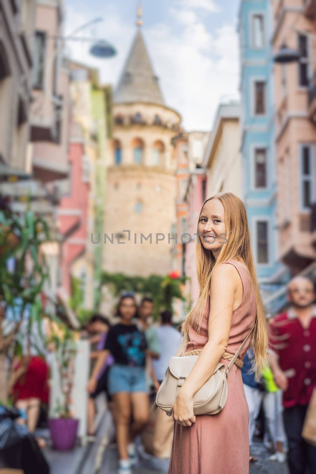 Portrait of beautiful woman tourist with view of Galata tower in Beyoglu, Istanbul, Turkey. Turkiye by galitskaya