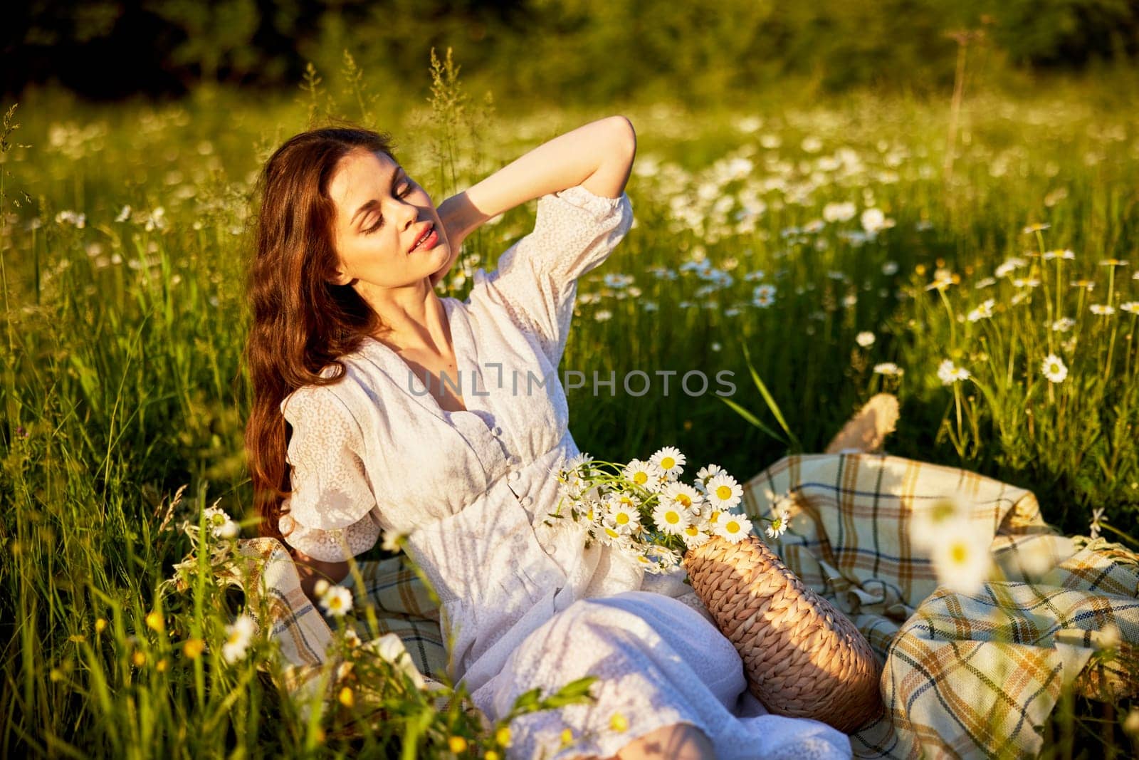 beautiful woman in a light dress lies in the green grass enjoying the sunset. High quality photo