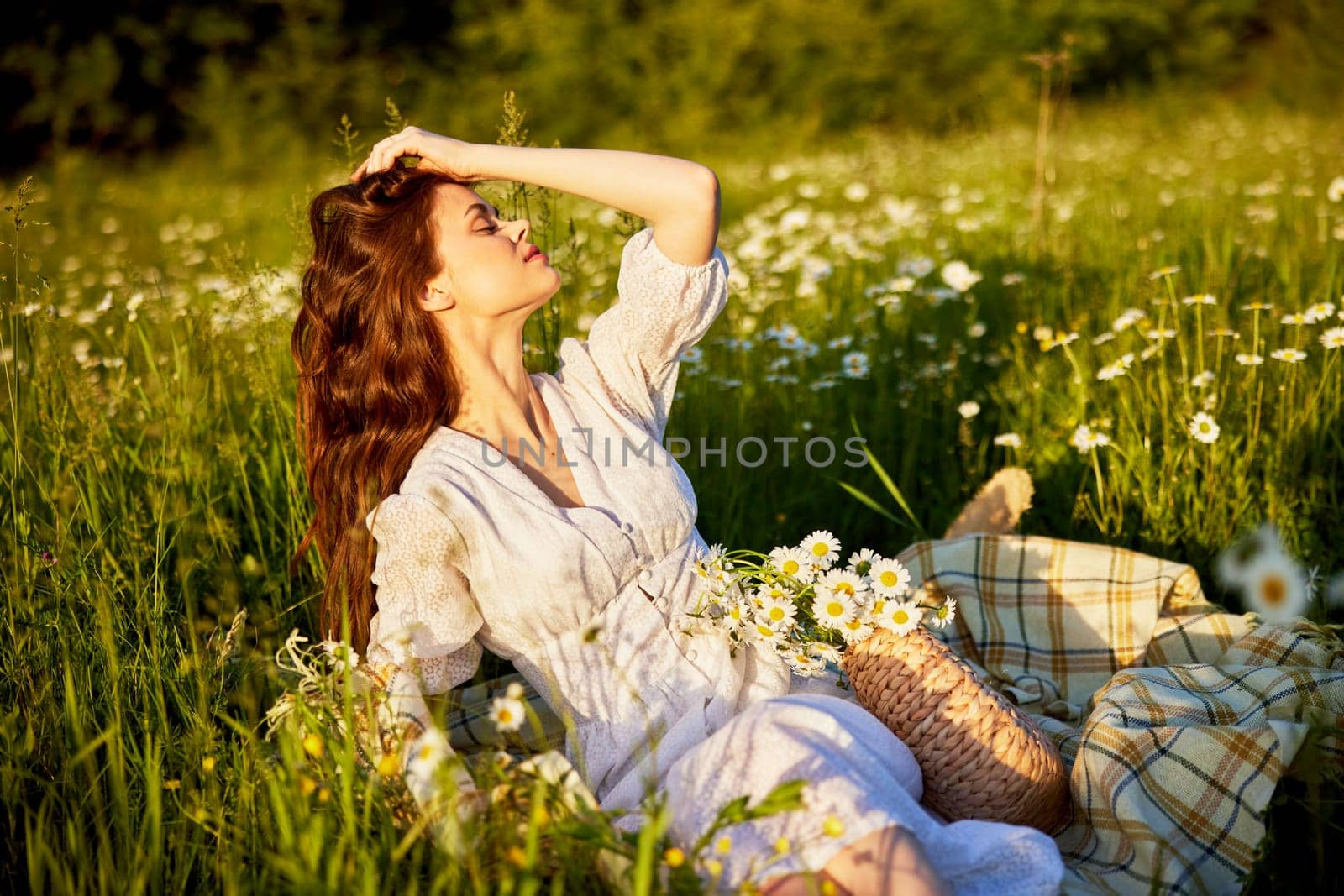 beautiful woman in a light dress lies in the green grass enjoying the sunset by Vichizh