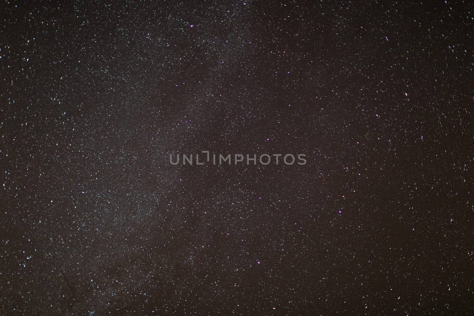 The small dots in the photo are stars from distant galaxies in a clear and cloudless sky at night. The universe in a small slice of the photo.