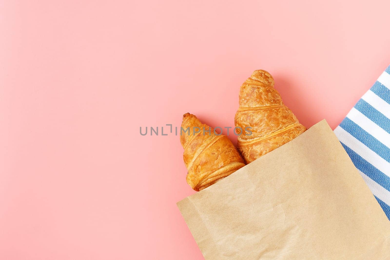 Delicious croissants in a package on a pink background. french pastries. copy space. by lara29