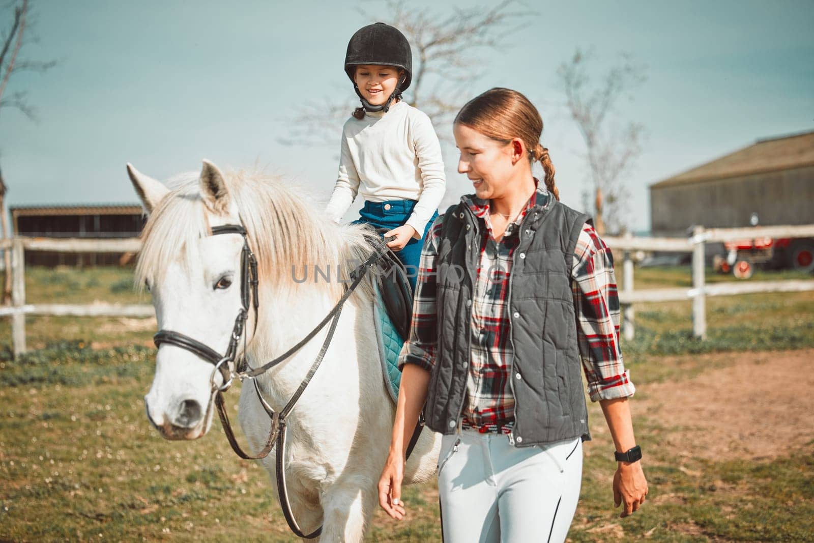 .Woman, child on horse and happy ranch lifestyle and animal walking on field with girl, mother and smile. Countryside, rural nature and farm animals, mom teaching and helping kid to ride pony in USA