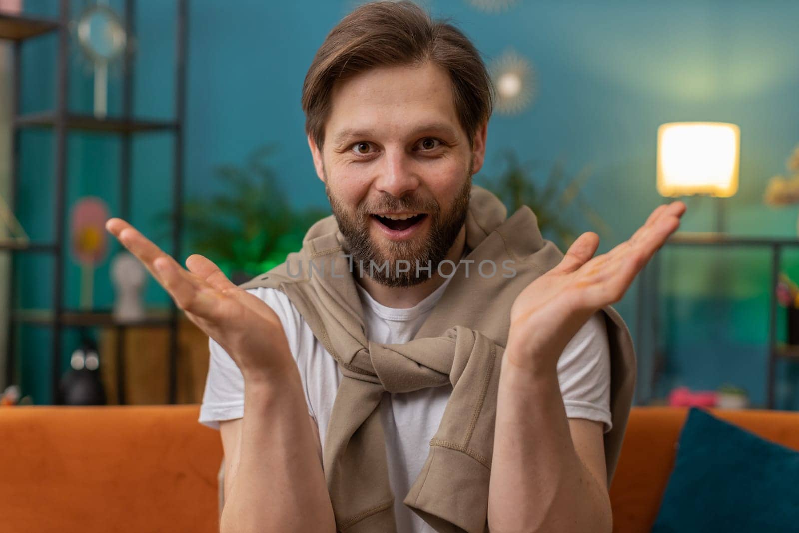 Oh my God, Wow. Excited amazed young man surprised looking at camera with big eyes, shocked by sudden victory, good win news, celebrating. Portrait of Caucasian guy at home apartment room on sofa