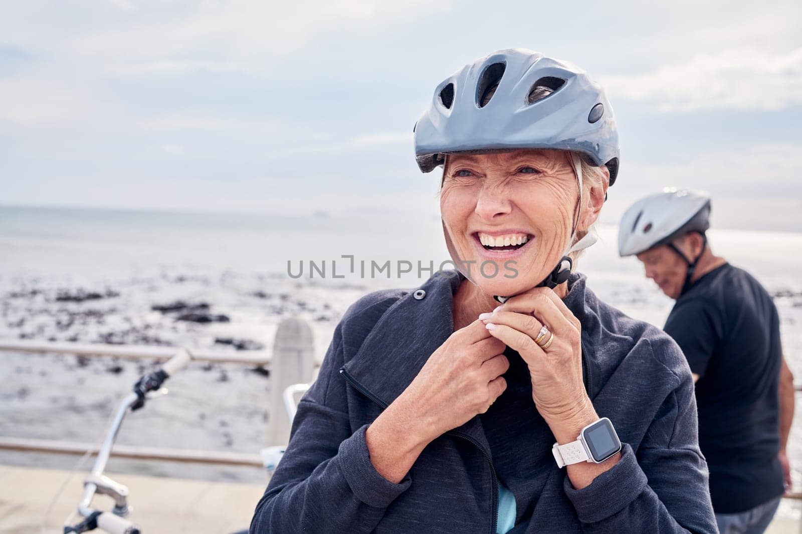 Happy senior woman, bicycle and helmet on holiday ride at beach for fitness workout with man. Smile on face, happiness and health, cycling exercise for mature couple on ocean vacation in Australia