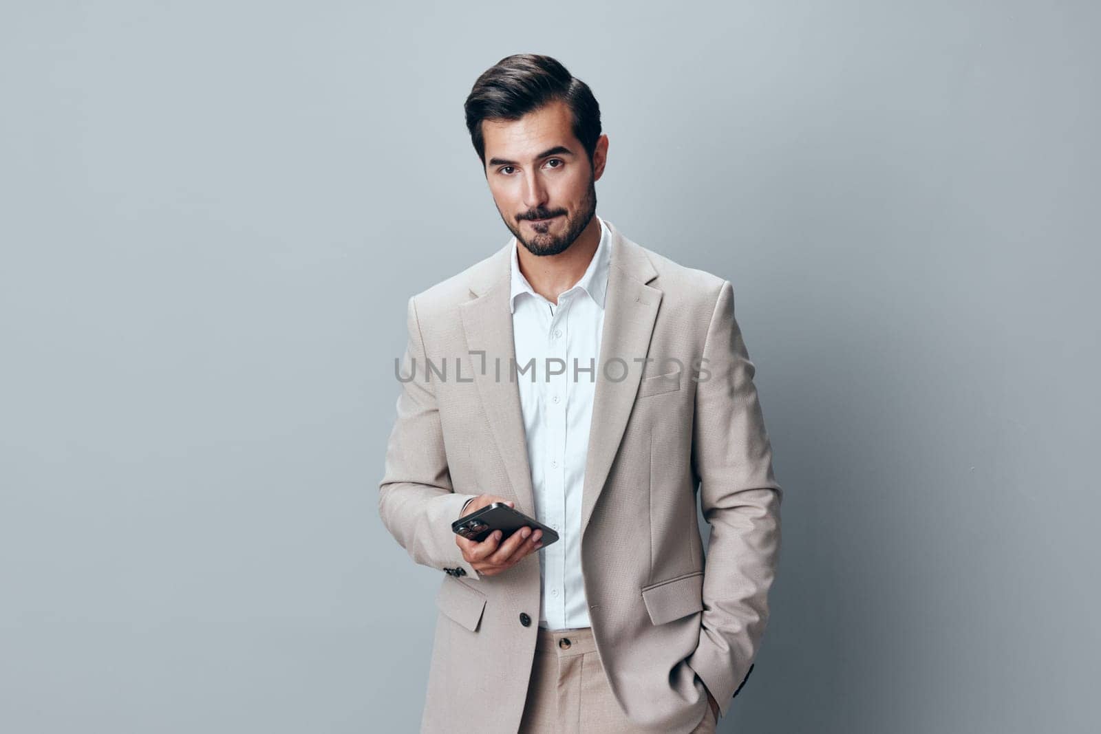 man beard studio portrait male entrepreneur success smartphone suit call white business handsome gray smile phone happy corporate internet hold lifestyle