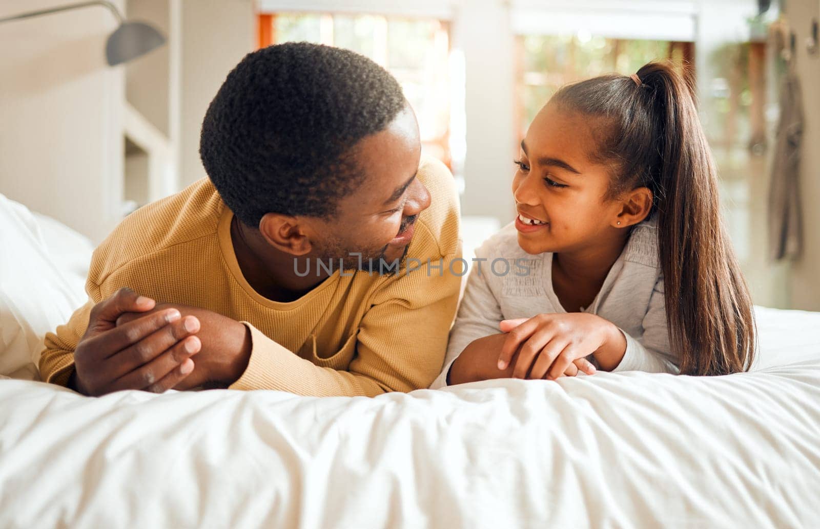 Family, father and girl child talking, spending quality time together with love and care, relax in bedroom at home. Black man, kid and happy people, communication and relationship with childhood by YuriArcurs