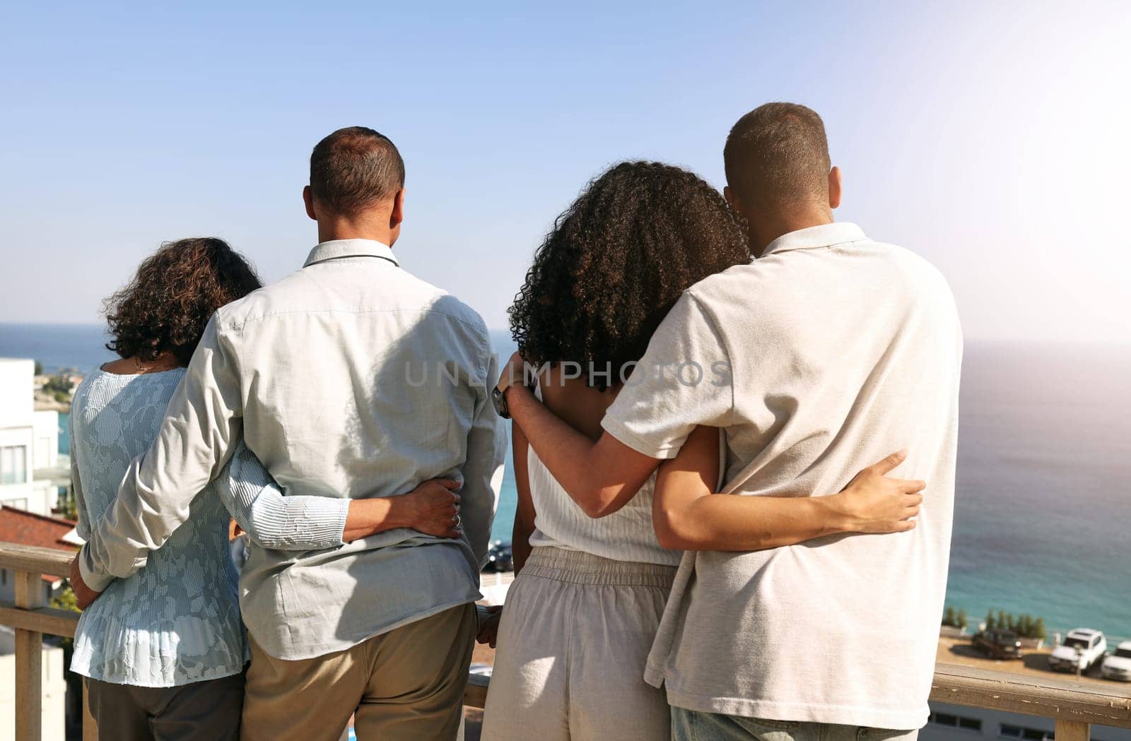 Hug, love and family with a view of ocean during a vacation, freedom and bonding in Bali. Affection, holiday and back of parents and couple on a balcony to look at the beach for a break and travel.