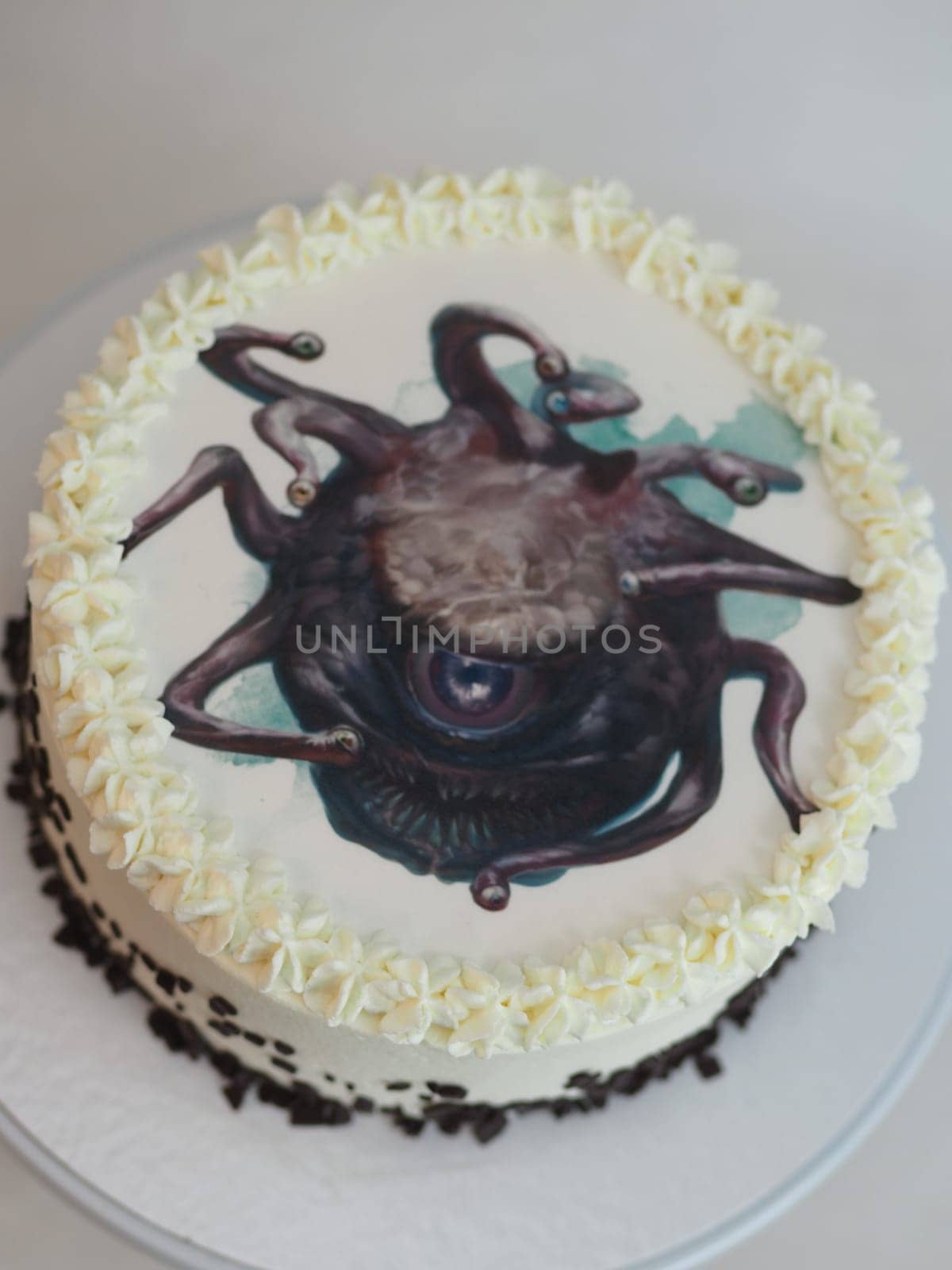 studio isolated shot of frosted white icing cake on white background with monster topping