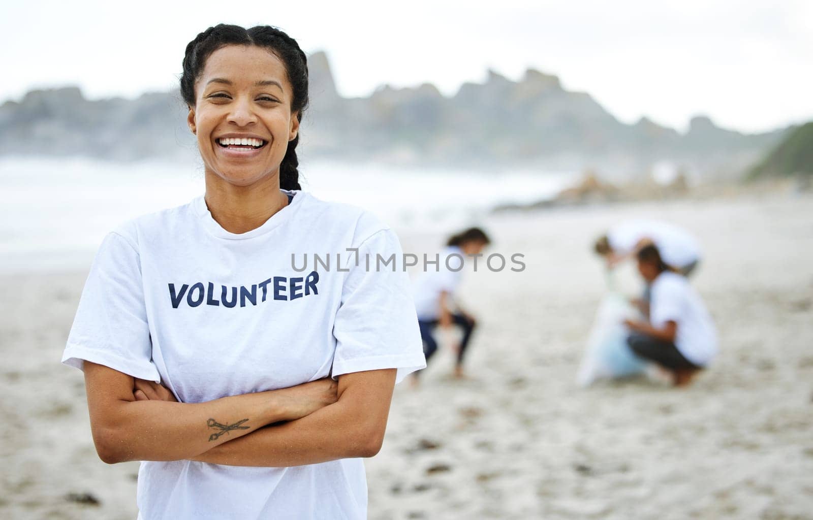 Portrait, smile and volunteer woman at beach for cleaning, recycling and sustainability. Earth day, laughing and proud female with arms crossed for community service, charity and climate change