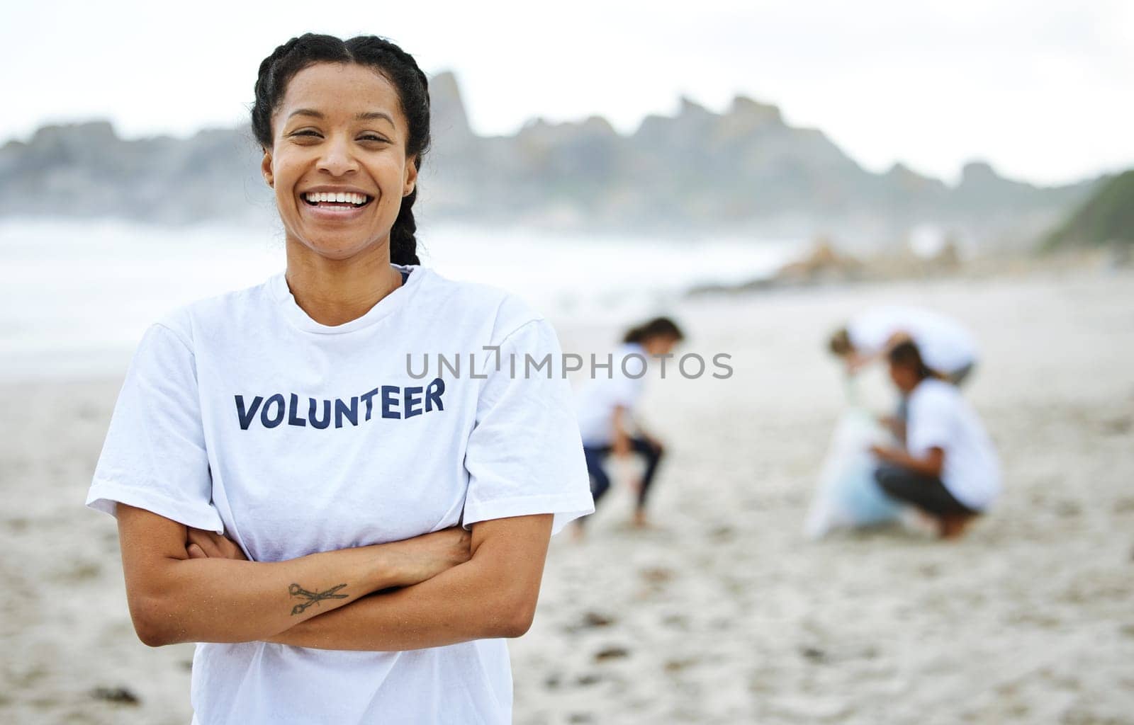 Portrait, smile and volunteer woman at beach for cleaning, recycling and environmental sustainability. Earth day, laughing and proud female with arms crossed for community service and climate change