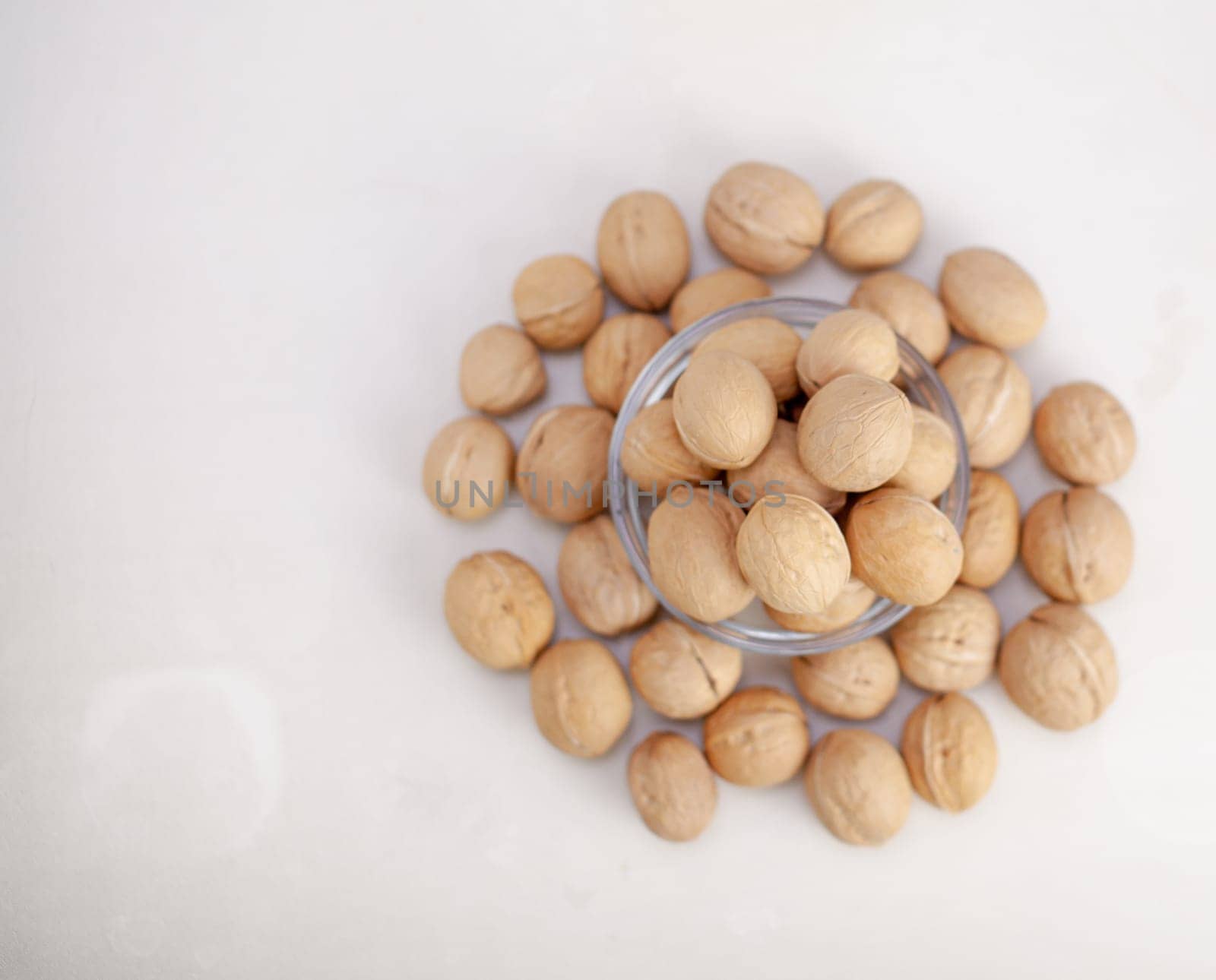 A lot of whole walnuts in a cup on a white background close-up. Healthy, organic food with a high content of protein and protein.