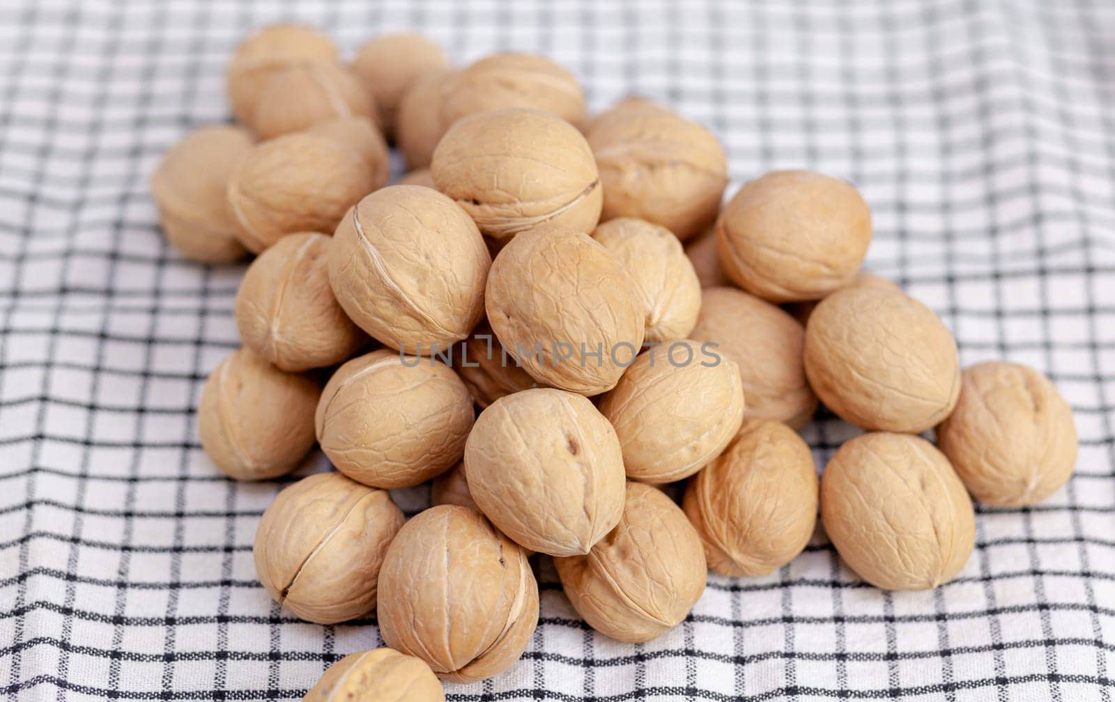 A lot of whole walnuts on a napkin close-up. Healthy, organic and healthy food with a high content of protein and protein.