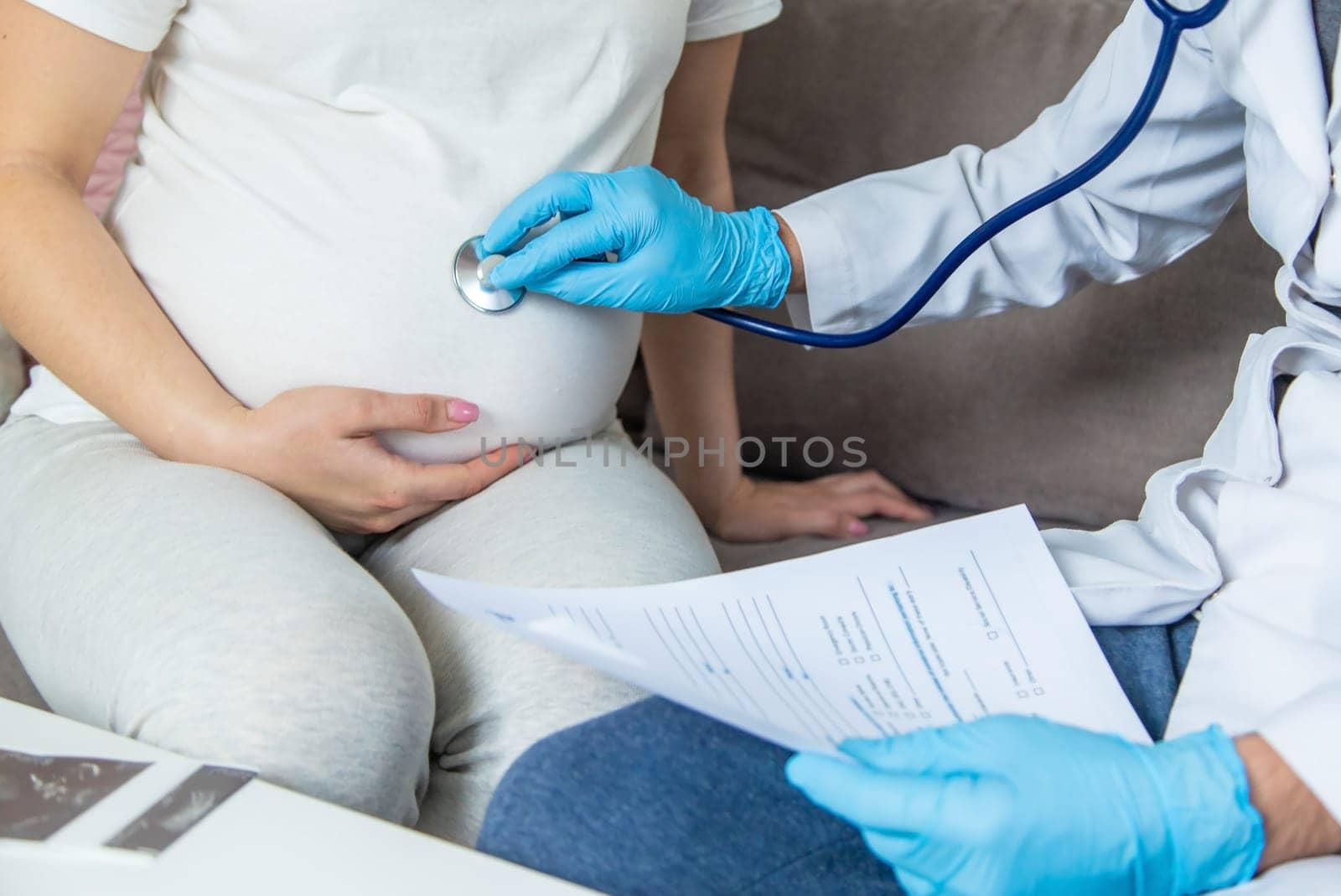 The doctor examines the belly of a pregnant woman. Selective focus. medicine.