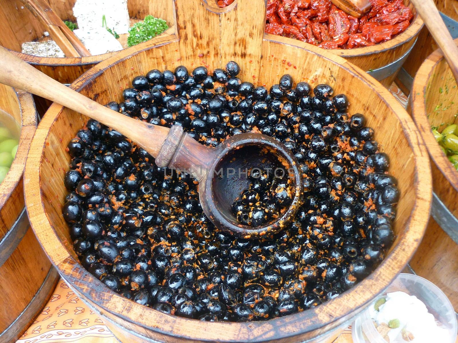 Black olives in wooden barrels on an olives stall in London Borough market