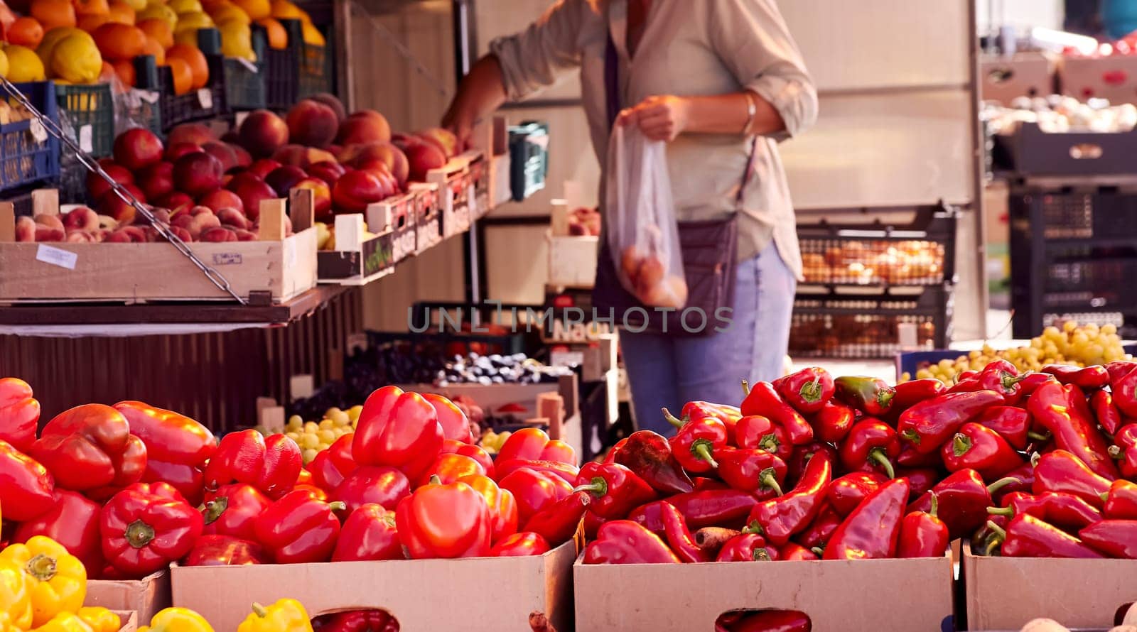 Red chili peppers with vegetables in the market. Tomatoes and peppers are selected by the buyer at the market.