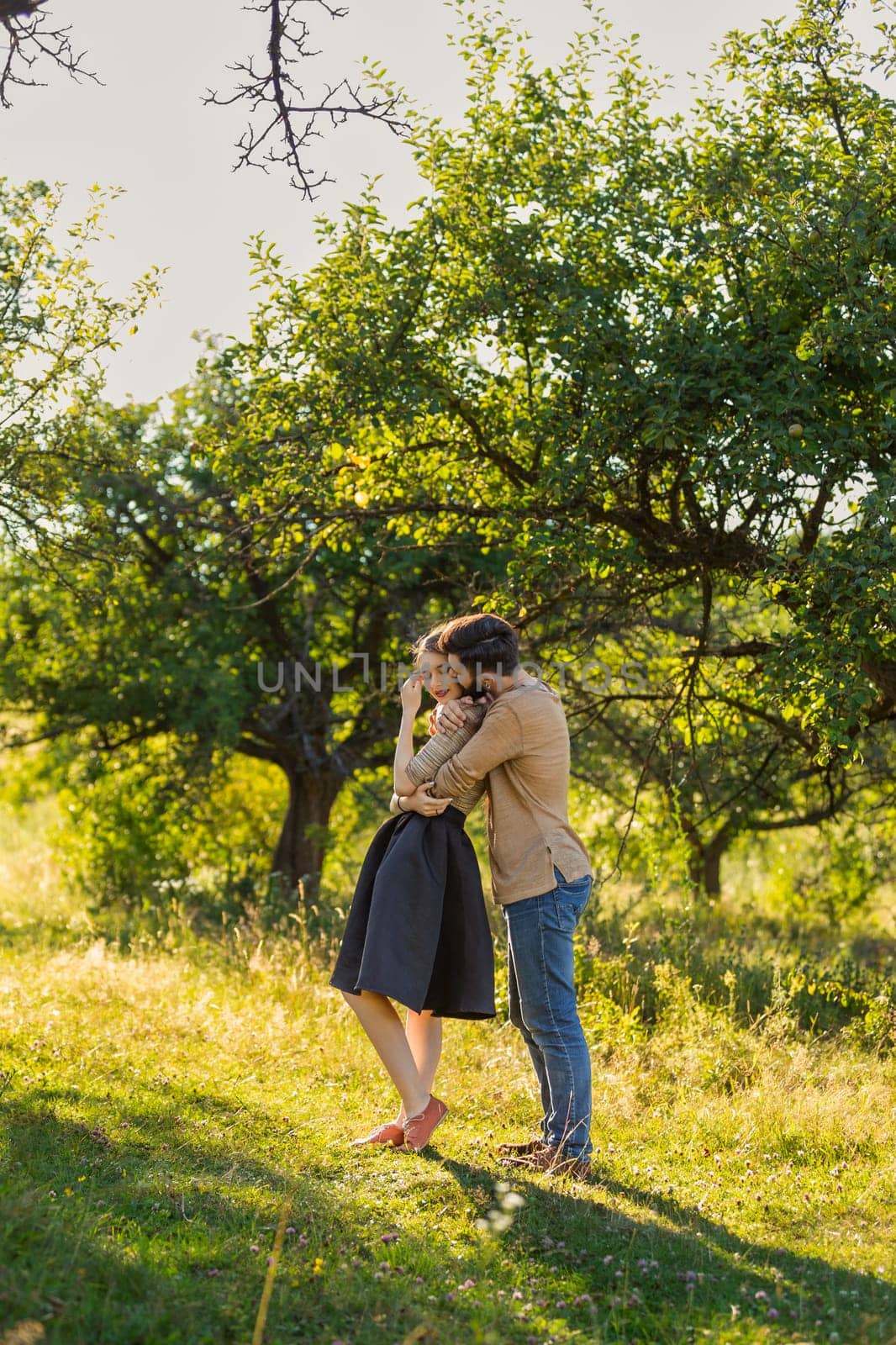 man hugging his girlfriend in nature