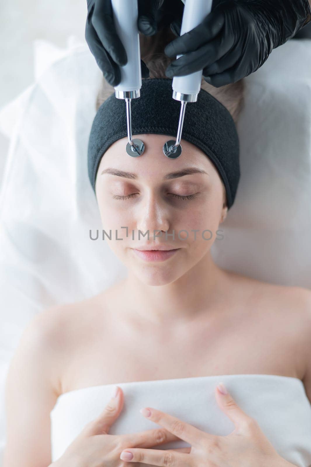 Young caucasian woman on microcurrent therapy procedure. Beautician's office