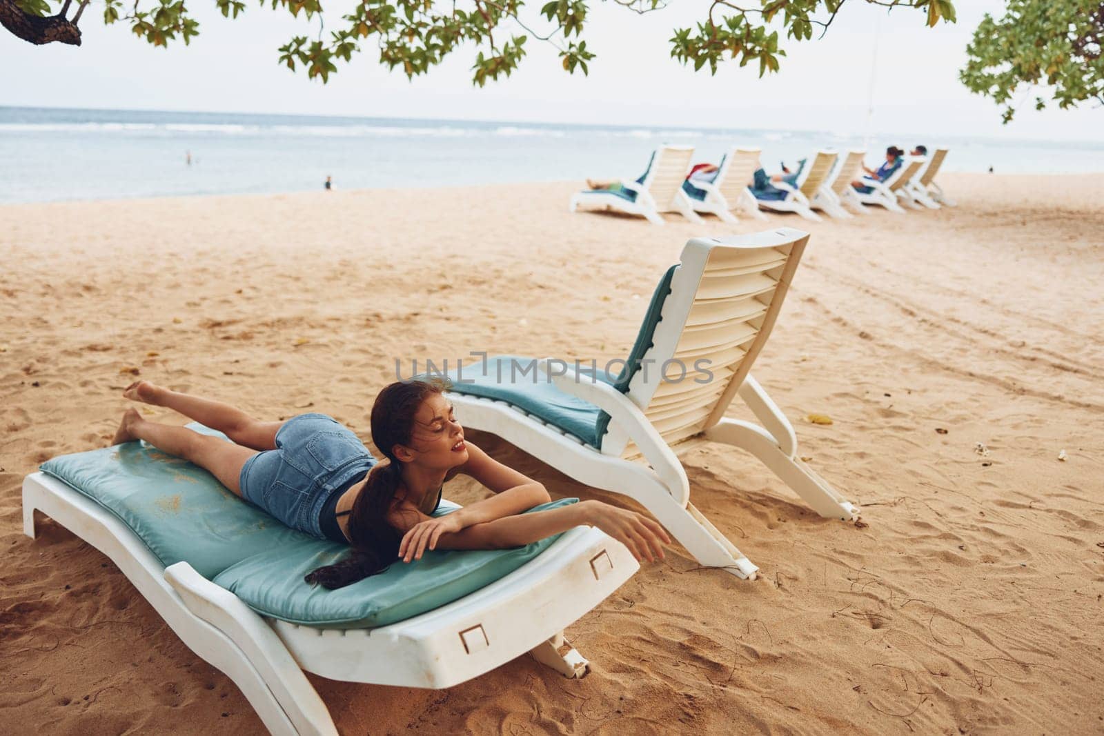 woman relax chair sunbed beach bikini holiday sitting tan caucasian lying smiling sea ocean resting water sand rest young lifestyle resort