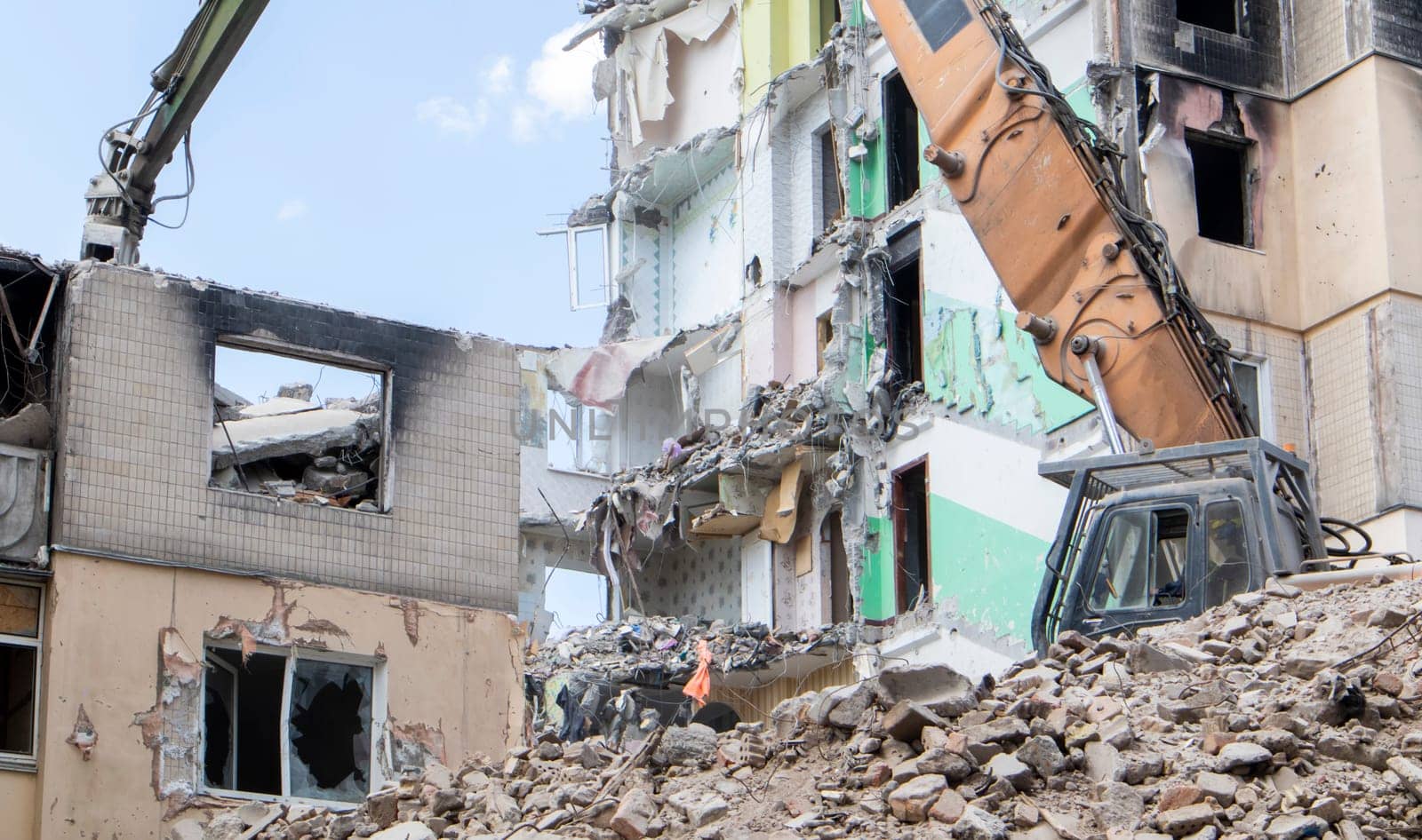 The process of demolition of the old dismantling of the building. The excavator breaks the house. Demolition of dilapidated housing. Construction digger demolishing a house for renovation