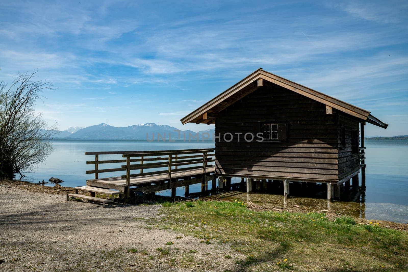 Wooden beach house at the chiemsee in Germany with the mountains of Austria with snow on the tops in the background