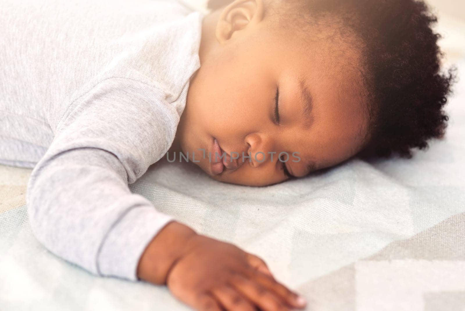 Baby, african and boy sleeping on bed for rest, health and peace for growth, development and relax in family home. Black male infant, tired and sleep in bedroom with fatigue, quiet and calm in house.