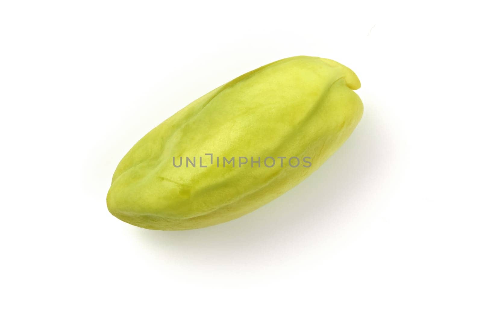 Single peeled green pistachio nut isolated on white background.