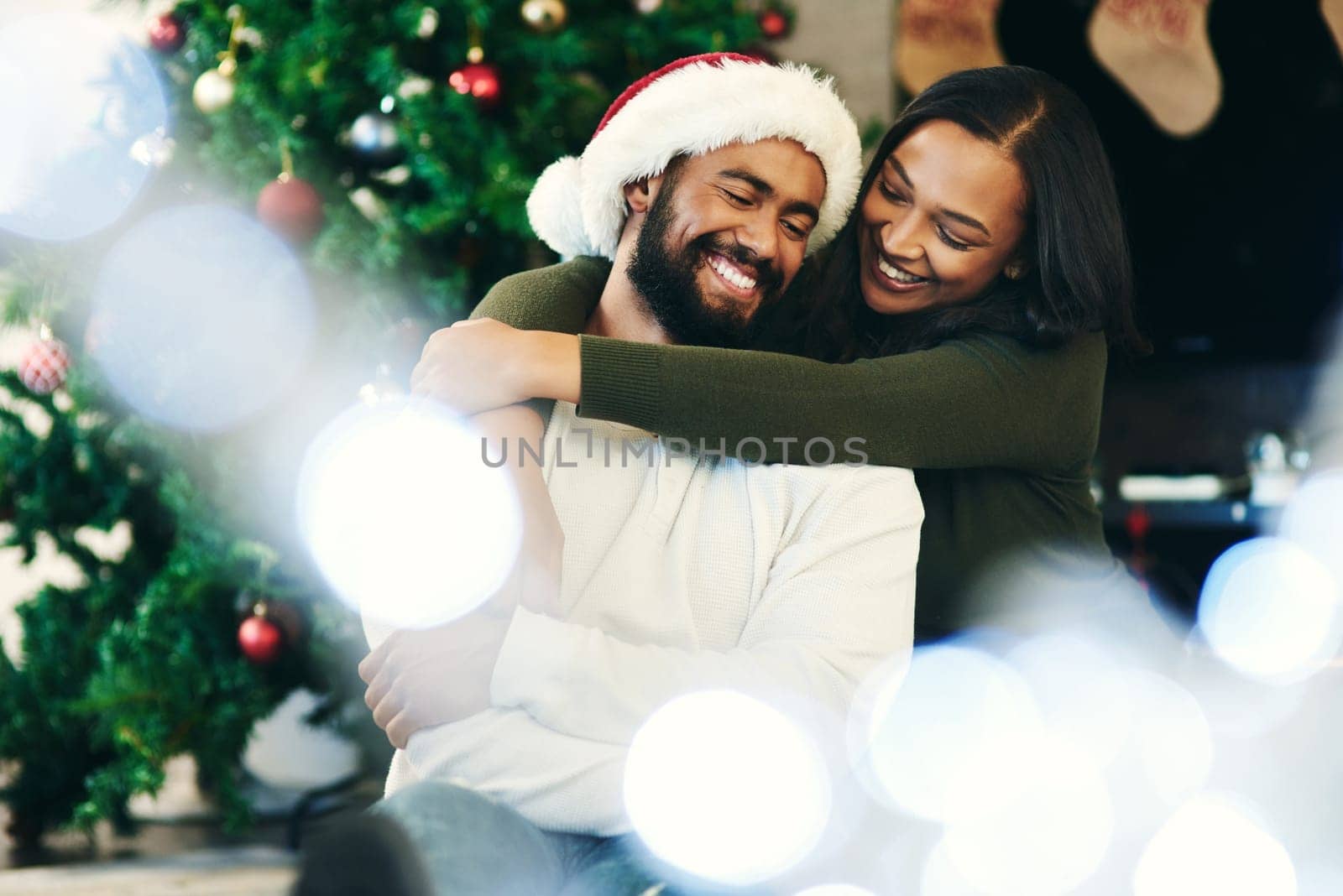 Black couple, Christmas celebration and hug with love, enjoy the festive season and relax in living room of apartment home. Happy man, black woman hugging and celebrate xmas December holiday together.