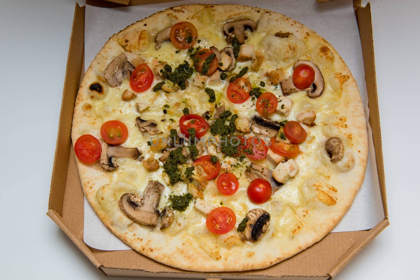 Whole Italian pizza pepperoni and cheese pizza in cardboard delivery box. Close-up. Selective focus.