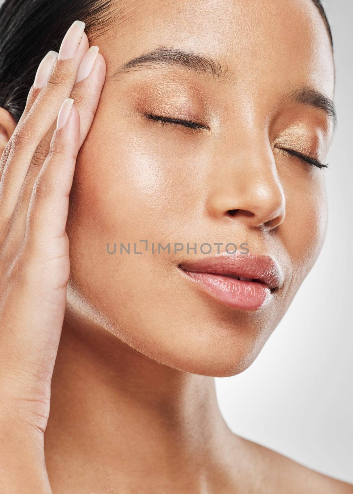 Glamour is a state of mind. Studio shot of an attractive young woman posing against a grey background. by YuriArcurs