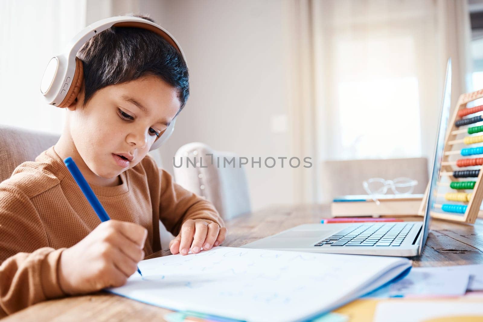 Learning headphones, math education and child in home with book for studying, homework or homeschool. Development, laptop or boy or kid with notebook for numbers in elearning, virtual or online class.