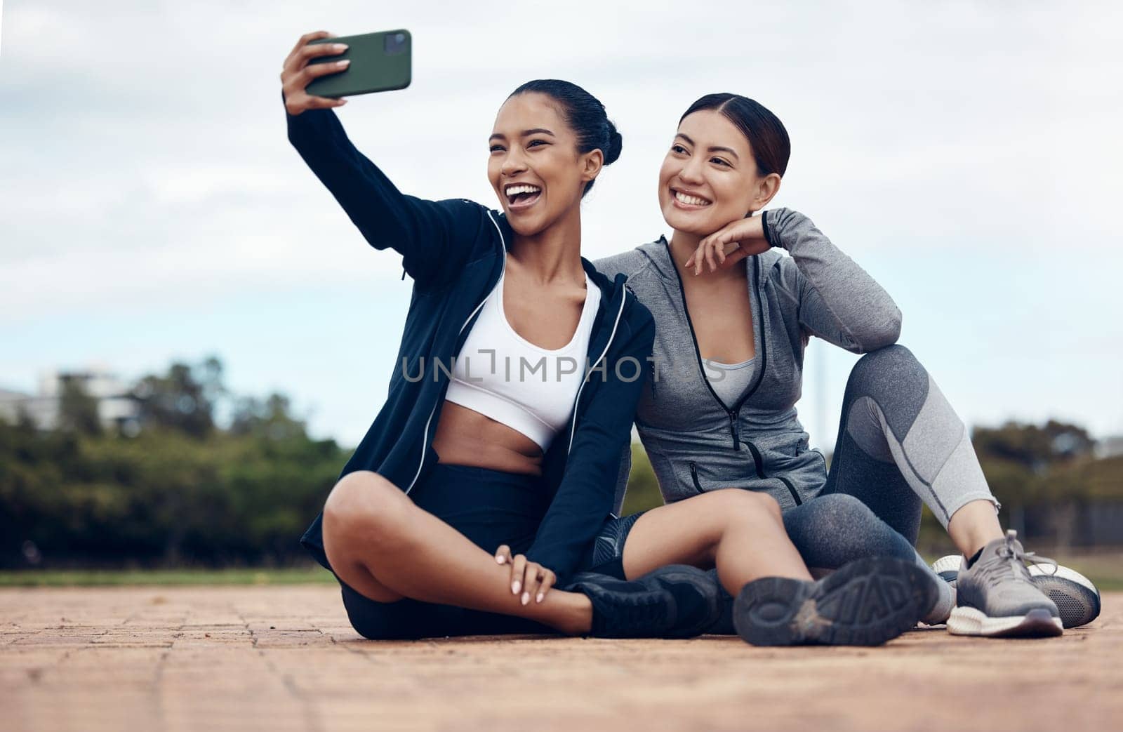 Selfie, women and friends outdoor for training, exercise and fitness for health, workout and wellness. Female trainers, healthy girls or with smartphone outside warm up, smile or relax in sportswear by YuriArcurs