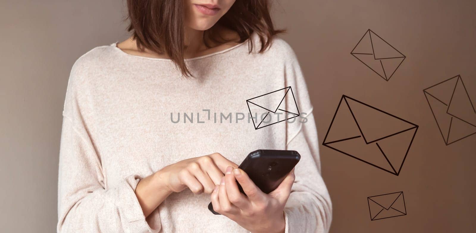 Young girl holds a smartphone in her hands and sends emails to friends, customers. Woman develops her business and communicates with people online, stylized letters are drawn over the mobile phone.