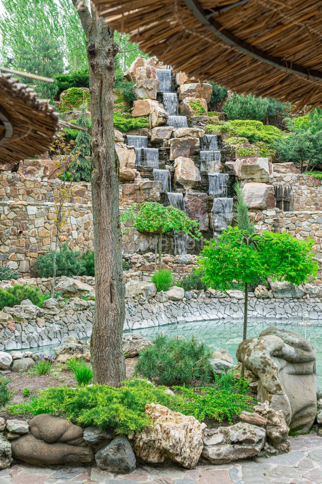 courtyard with waterfall and swimming pool in the hotel by roman112007