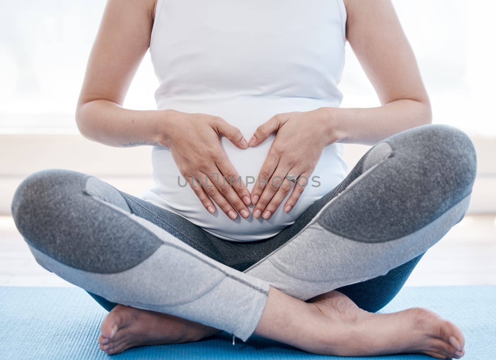 Woman, pregnant and yoga with lotus, floor or relax for health, exercise and wellness for body, mind and peace. Girl, pregnancy pilates and zen meditation with mindfulness in gym, studio or house.
