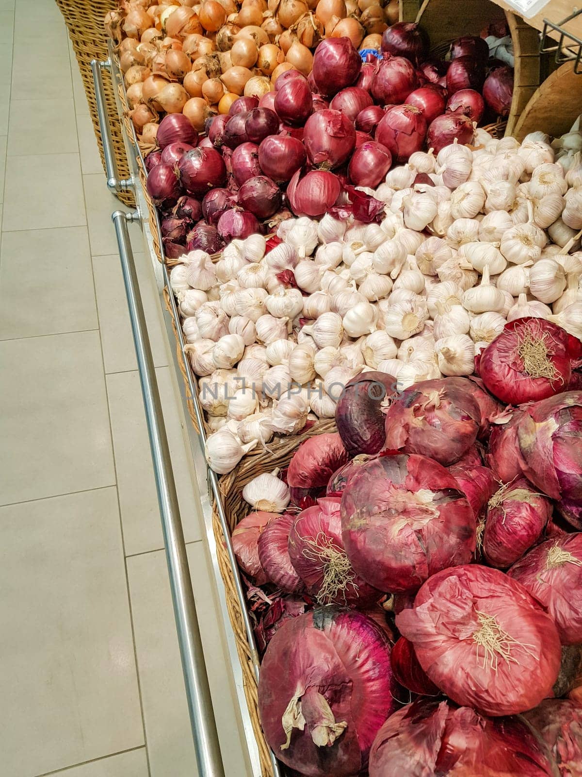 Close-up view of the counter in the vegetable market, sale of onions and garlic of different varieties by claire_lucia
