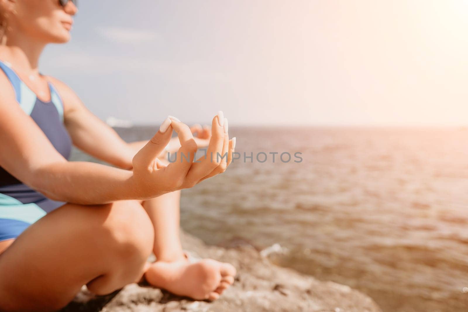 Woman sea yoga. Back view of free calm happy satisfied woman with long hair standing on top rock with yoga position against of sky by the sea. Healthy lifestyle outdoors in nature, fitness concept.